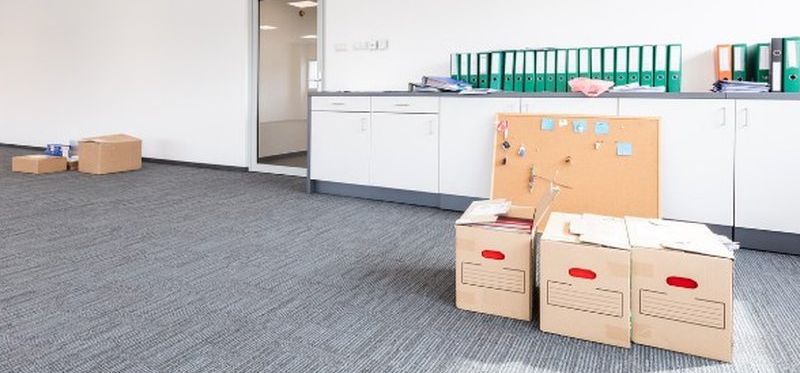 Cajas de archivo y carpetas en una oficina vacía, listas para el traslado