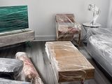Sofá, televisor, mesa y alfombras protegidos con film para la mudanza