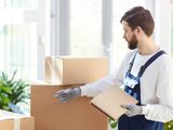 Operario de mudanzas con guantes revisando el inventario de las cajas
