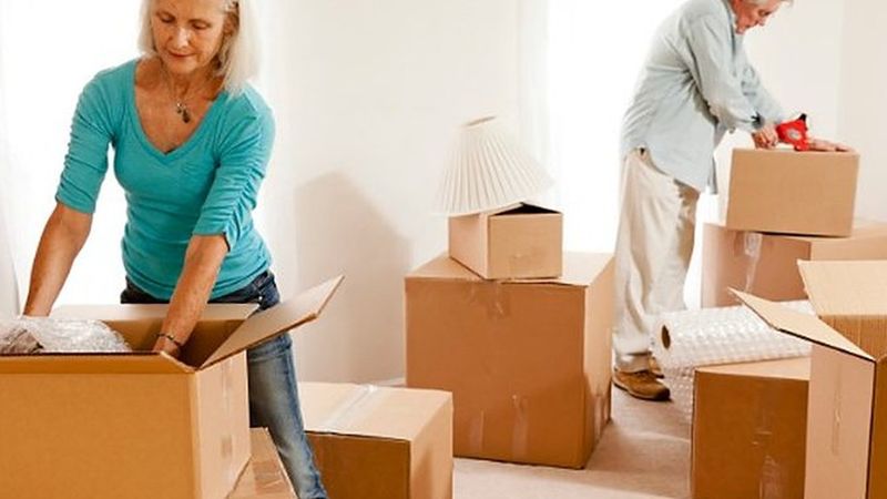 Pareja embalando cajas de cartón en casa antes de la mudanza