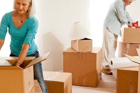 Pareja embalando cajas de cartón en casa antes de la mudanza