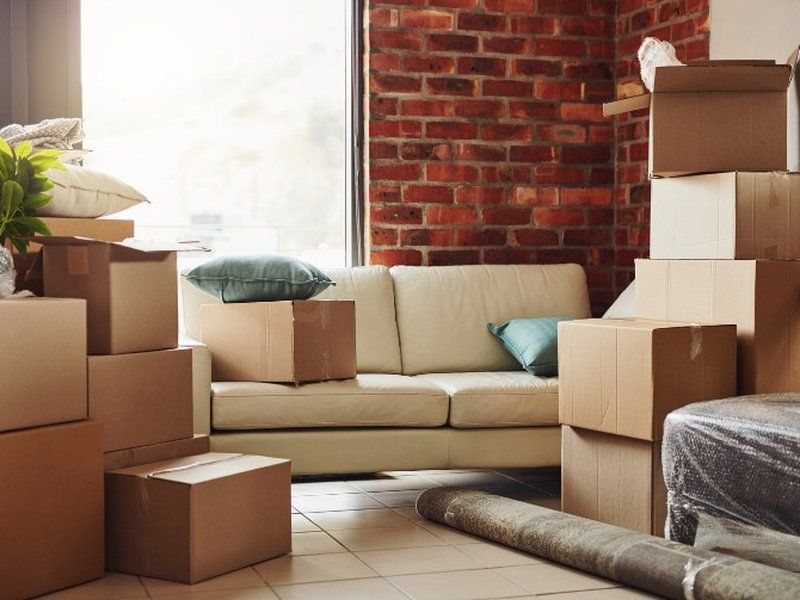 Salón con sofá y cajas de mudanza preparadas para el traslado